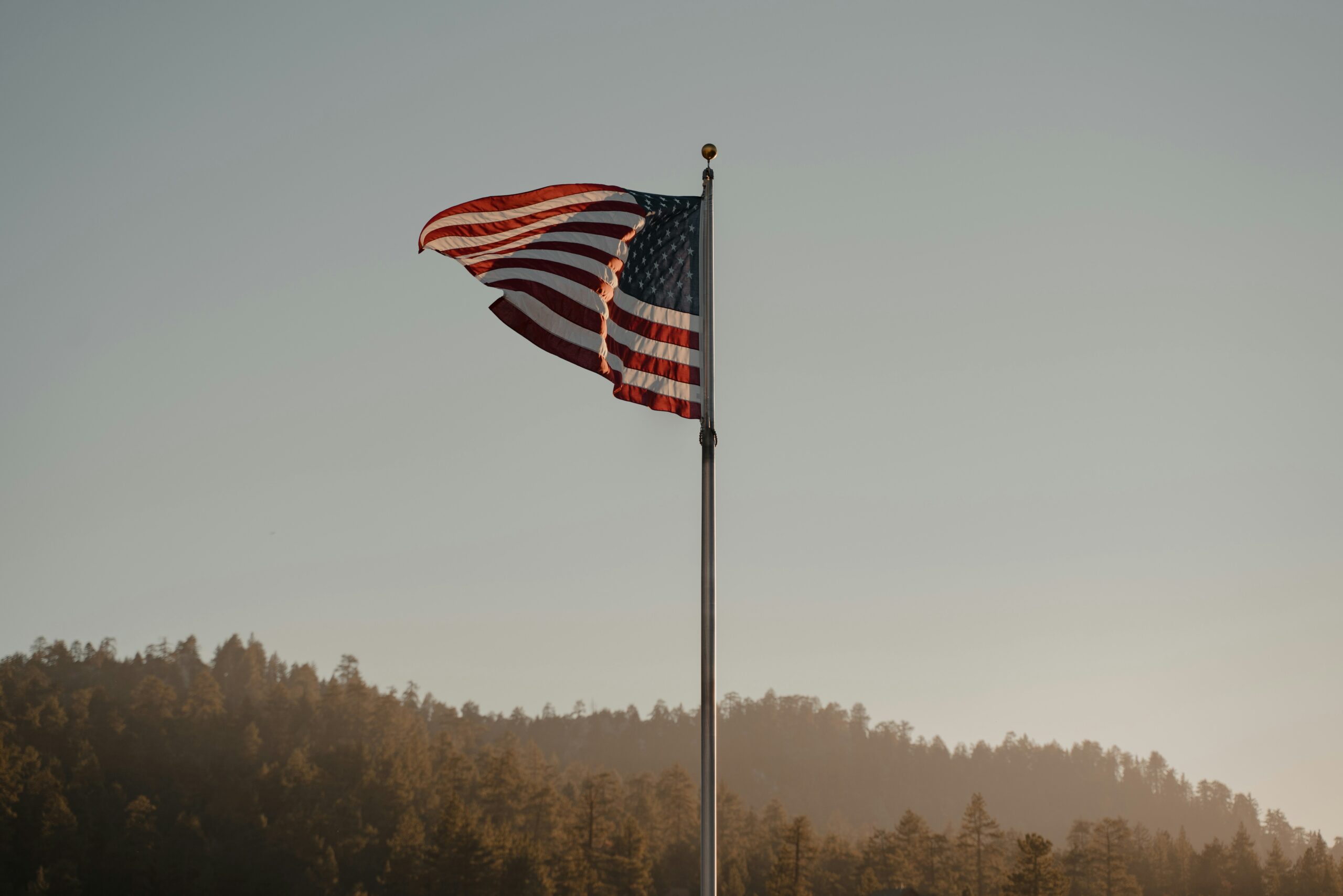 An American flag waving against a blue sky