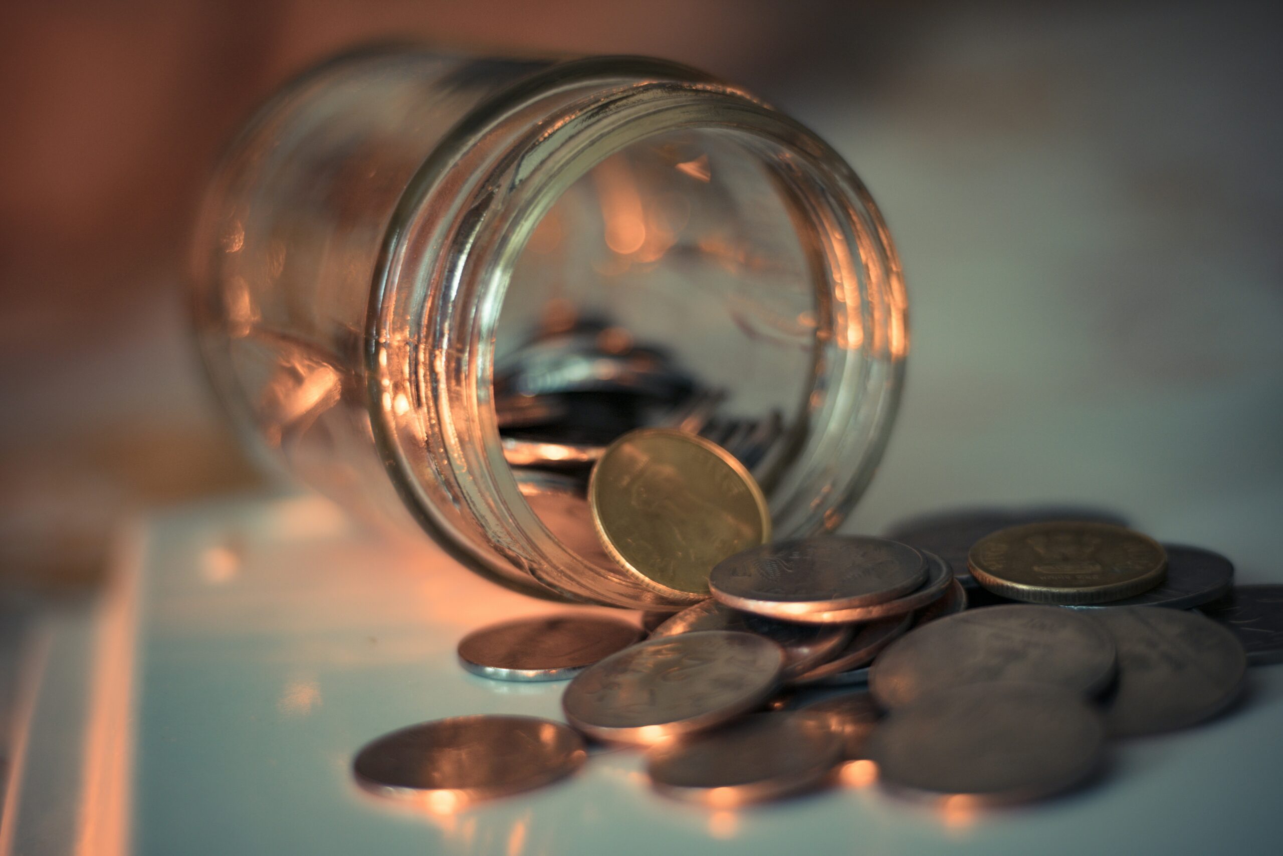 A clear glass jar filled with coins, representing grassroots campaign donations