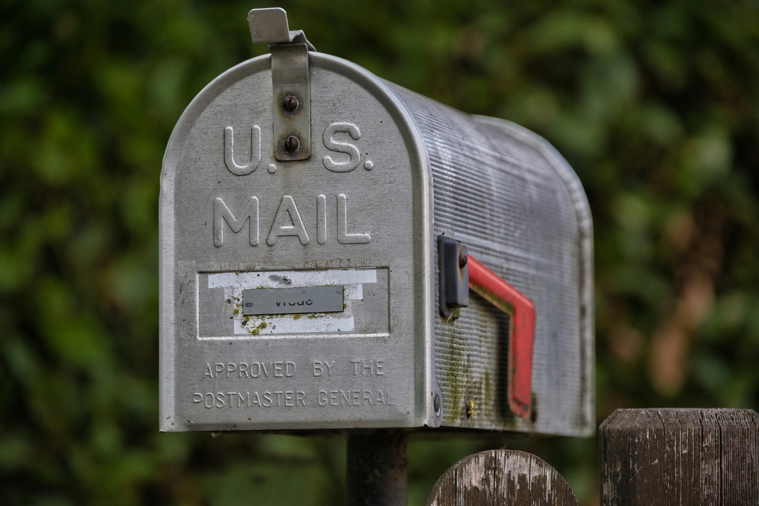 A weathered U.S. mailbox with its red flag raised