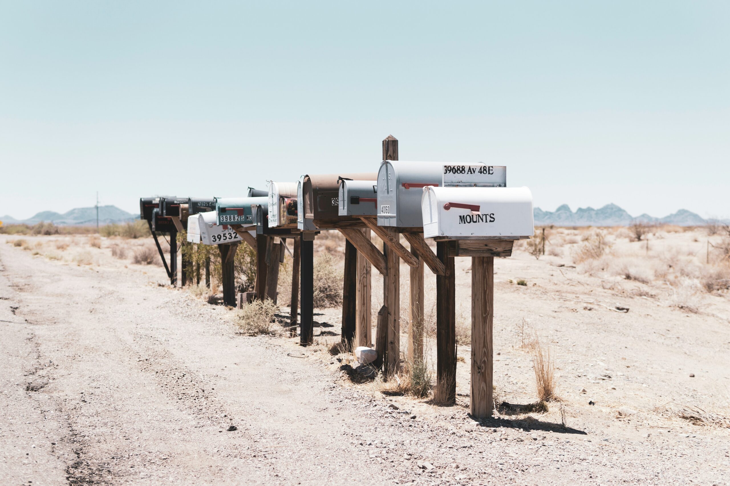 A row of rural mailboxes along a dirt road